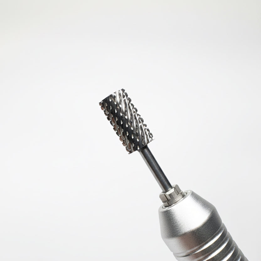 Close-up of a metallic rotary tool bit with a spiral wire brush attachment, shown against a soft gray gradient background.