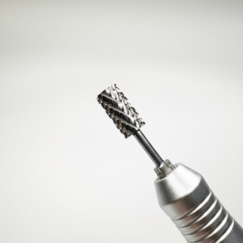 Close-up of a metallic rotary tool bit with a black shaft and a multi-toothed cutting or grinding head, shown against a soft gray gradient background.