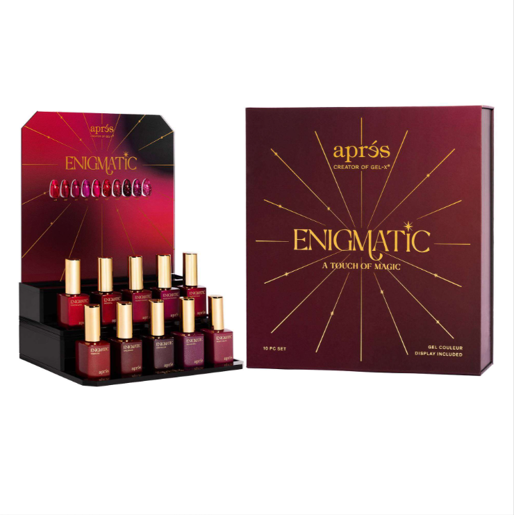 Après Enigmatic nail polish set featuring a black display tray with multiple bottles of deep berry-red and mauve polishes, alongside the product box in a matching dark red and gold design.