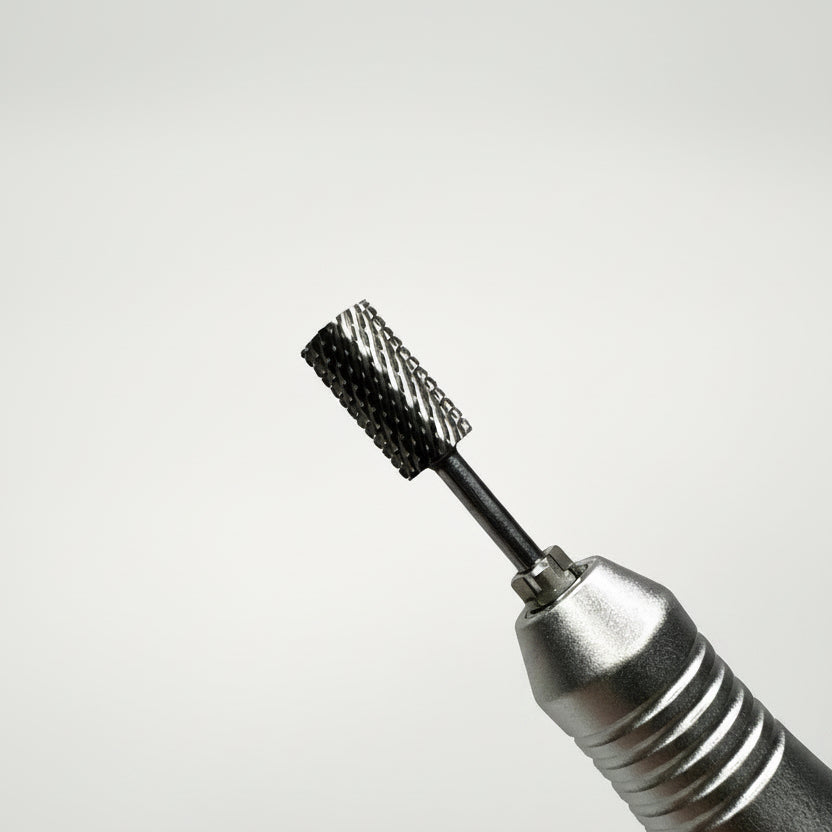 Close-up of a metallic rotary tool bit attachment with a textured black bristle head, shown against a soft gray gradient background.