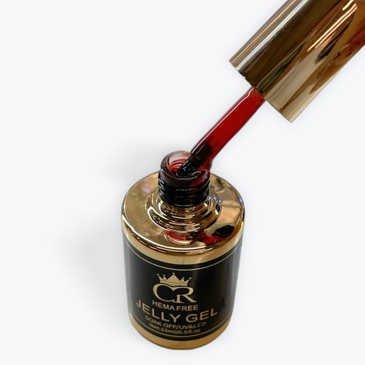 Gold and black jelly gel bottle with red liquid being poured on a white background