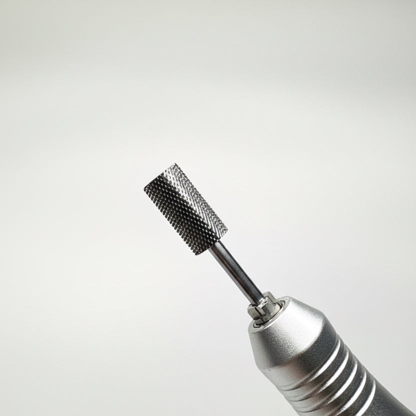 Close-up of a metallic rotary tool bit attachment with a textured cylindrical cutting or grinding head, shown against a soft gray gradient background.