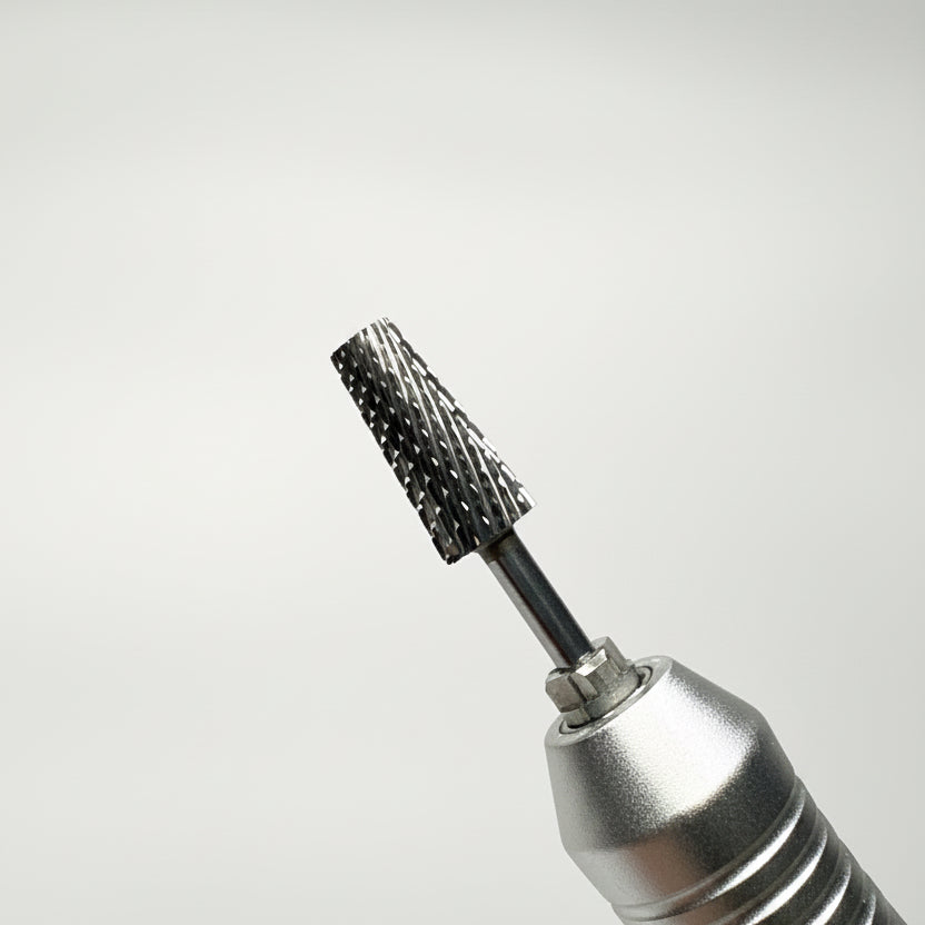 A close-up of a metallic rotary tool bit with a textured, bristle-covered cutting head, shown against a soft gray gradient background.