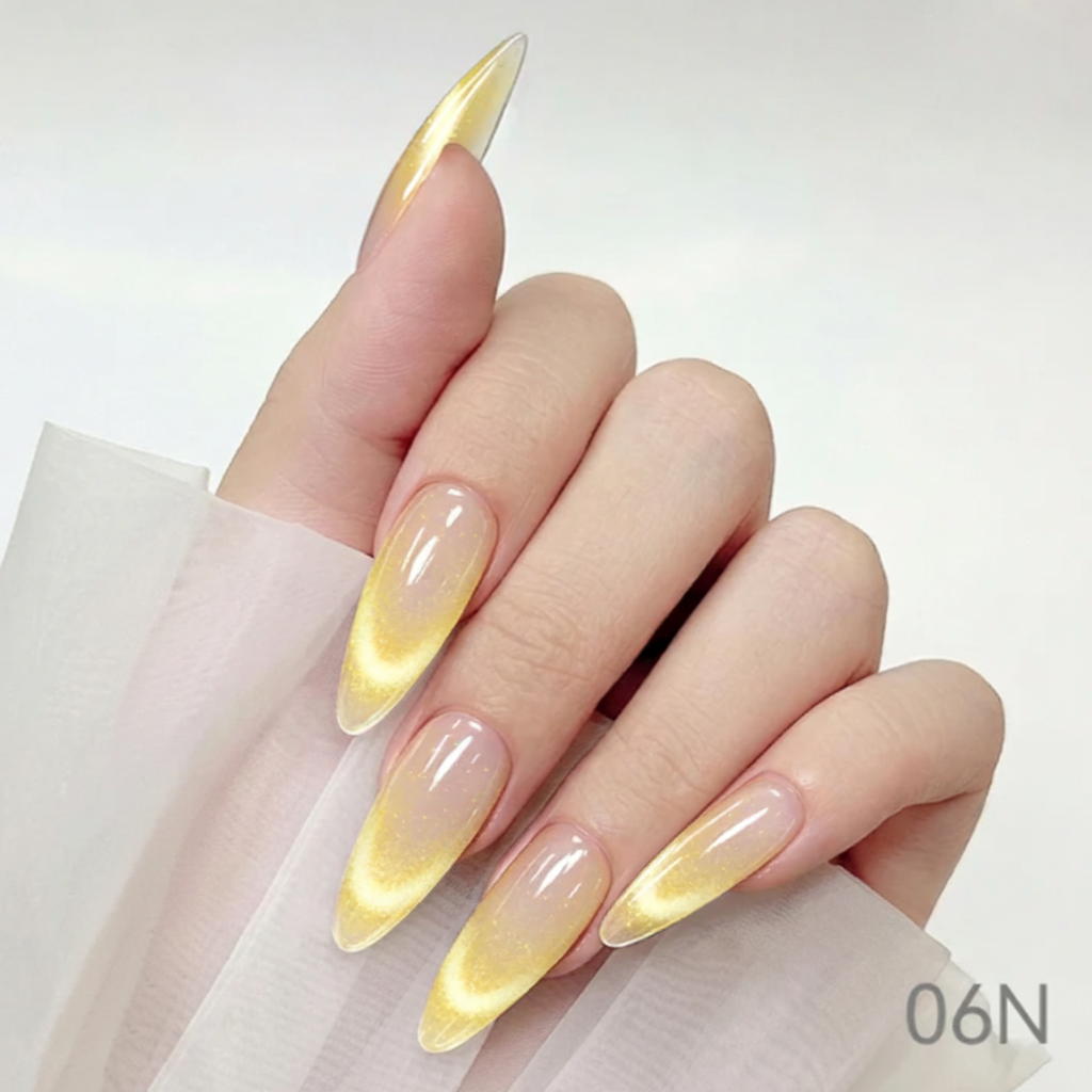 Hand with yellow and clear ombre nails holding a bottle of nail polish with 'Cre8tion' branding.