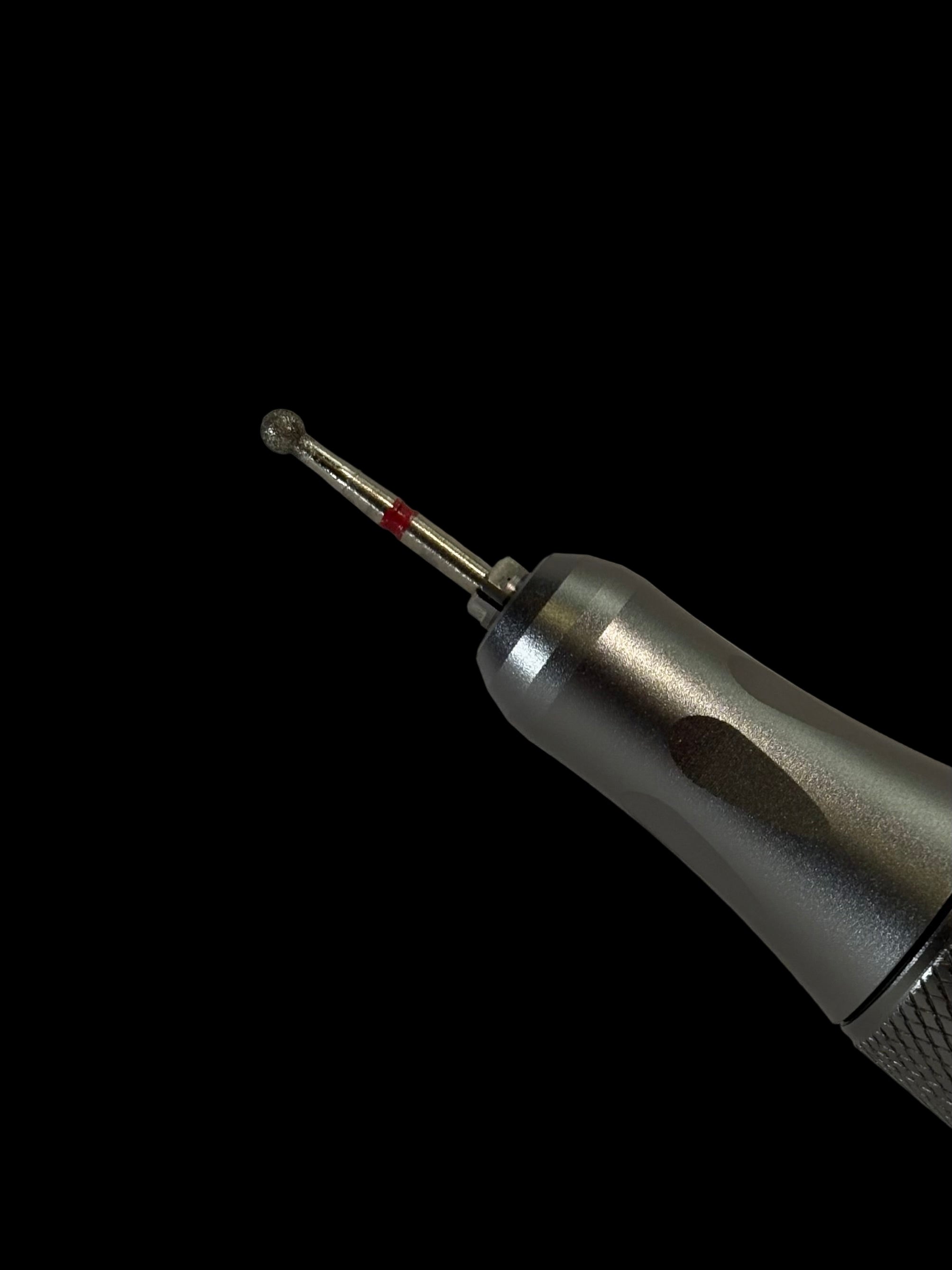 Close-up of a dental drill bit on a gray background
