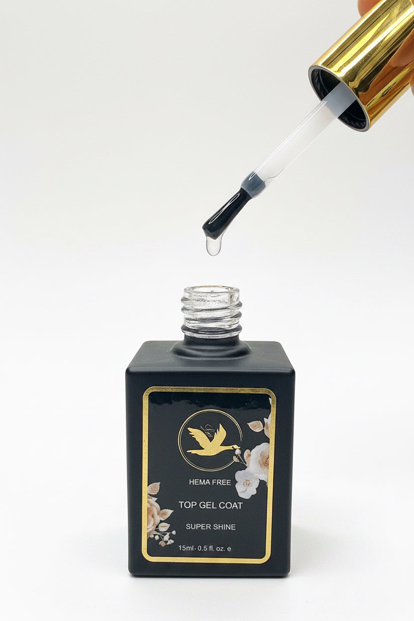 A bottle of HEMA-free Top Gel Coat nail polish with a gold cap, shown with its applicator dropper hovering above the open bottle, on a clean white background.