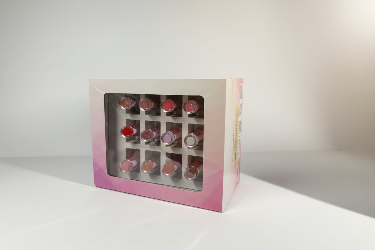 Set of lipsticks in a pink box on a white background