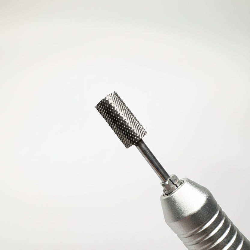 A close-up of a metallic rotary tool bit attachment with a textured, knurled cylindrical head and a black shaft, shown against a soft gray gradient background.