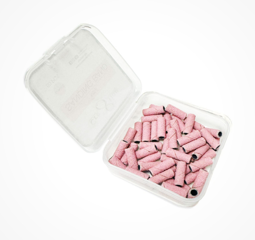 Clear plastic container with pink cylindrical objects on a white background