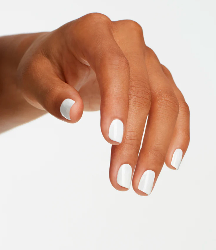 Hand with white nail polish on a light gray background