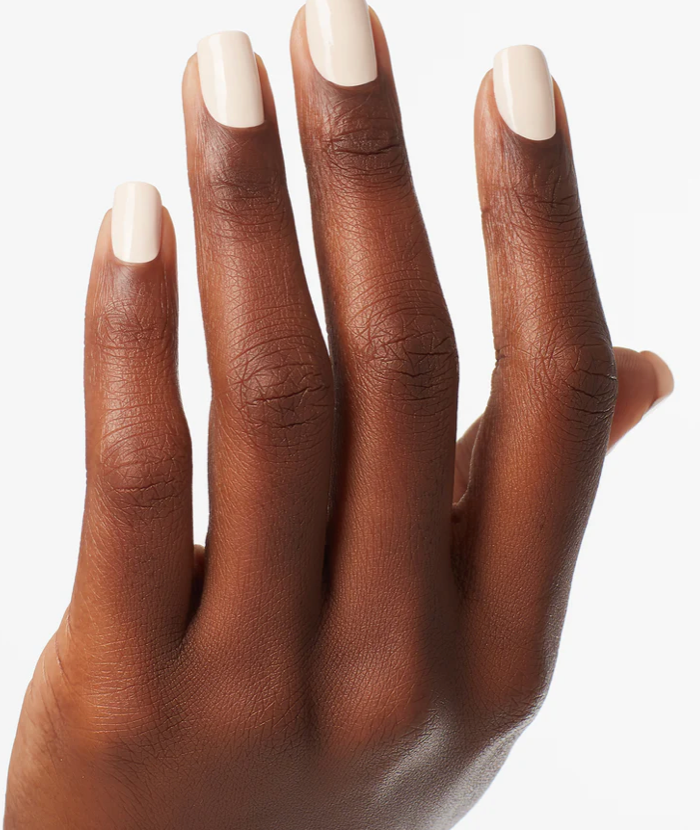 Hand with dark skin and white nail polish on a white background
