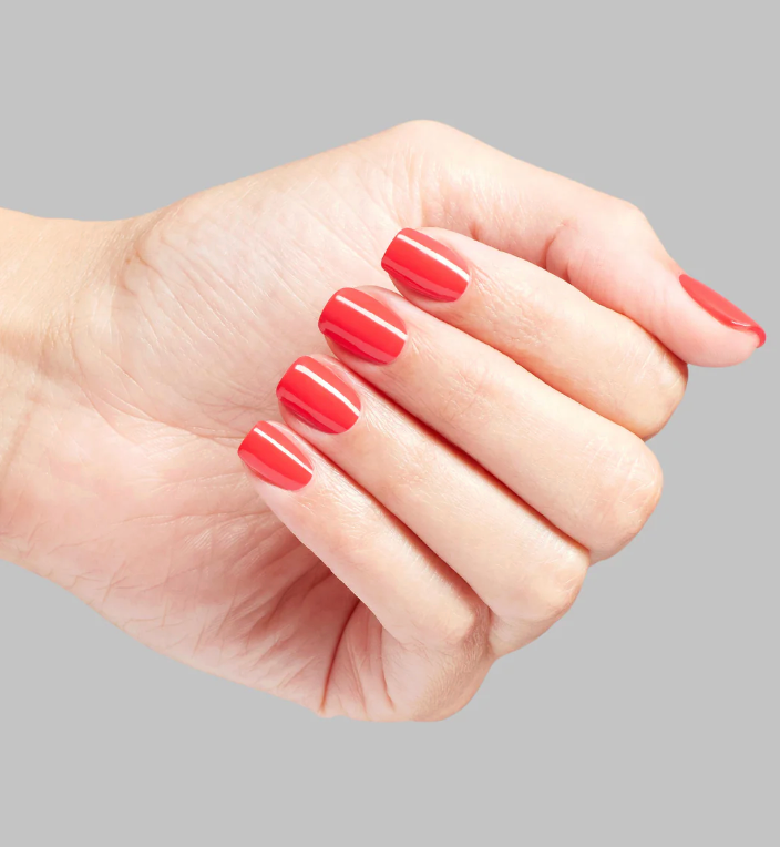 Hand with red nail polish on a gray background