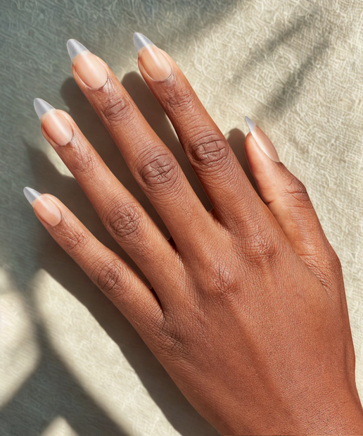 Hand with beige nail polish on a neutral background