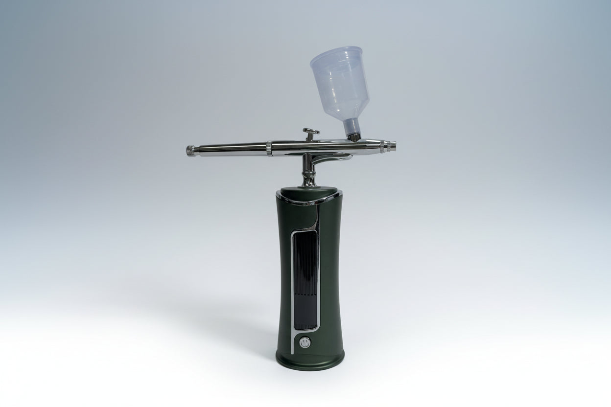 Green airbrush gun with a clear container on a white background