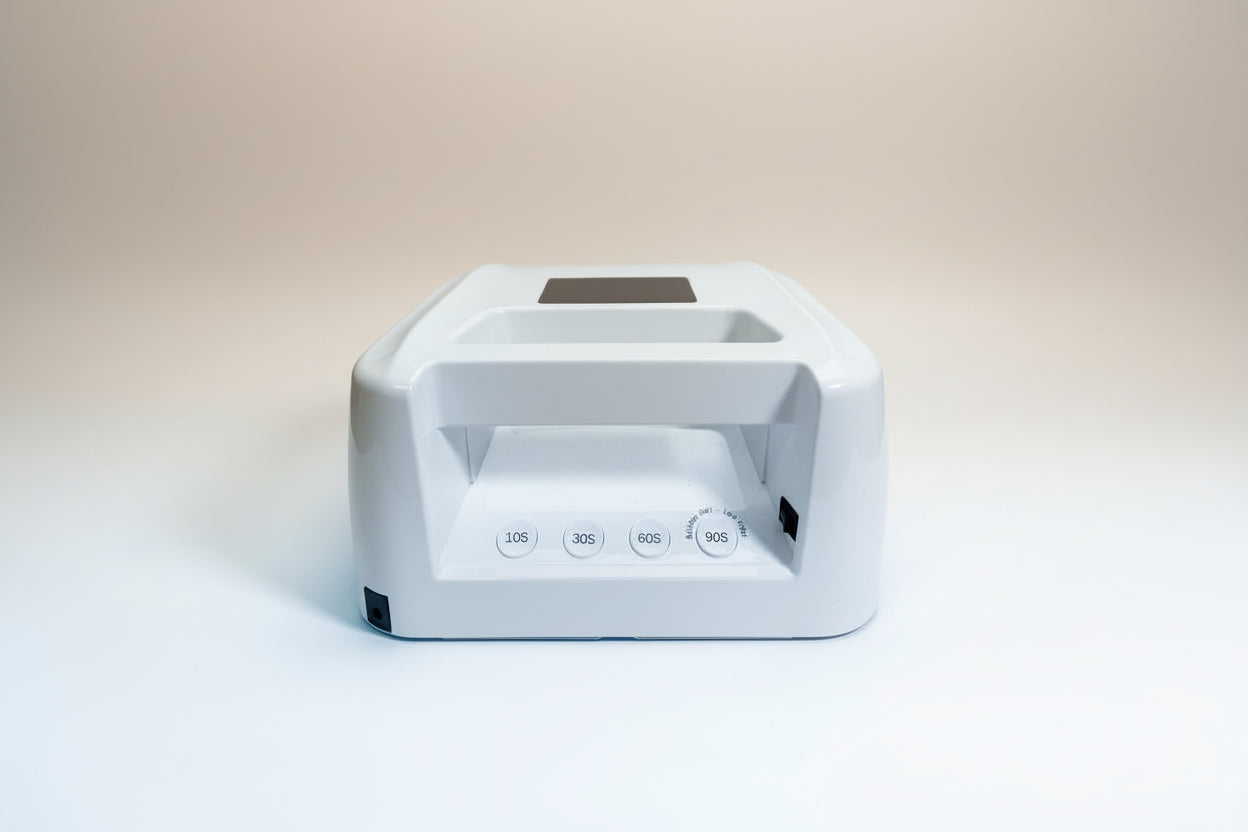White nail dryer with timer settings on a light gray background