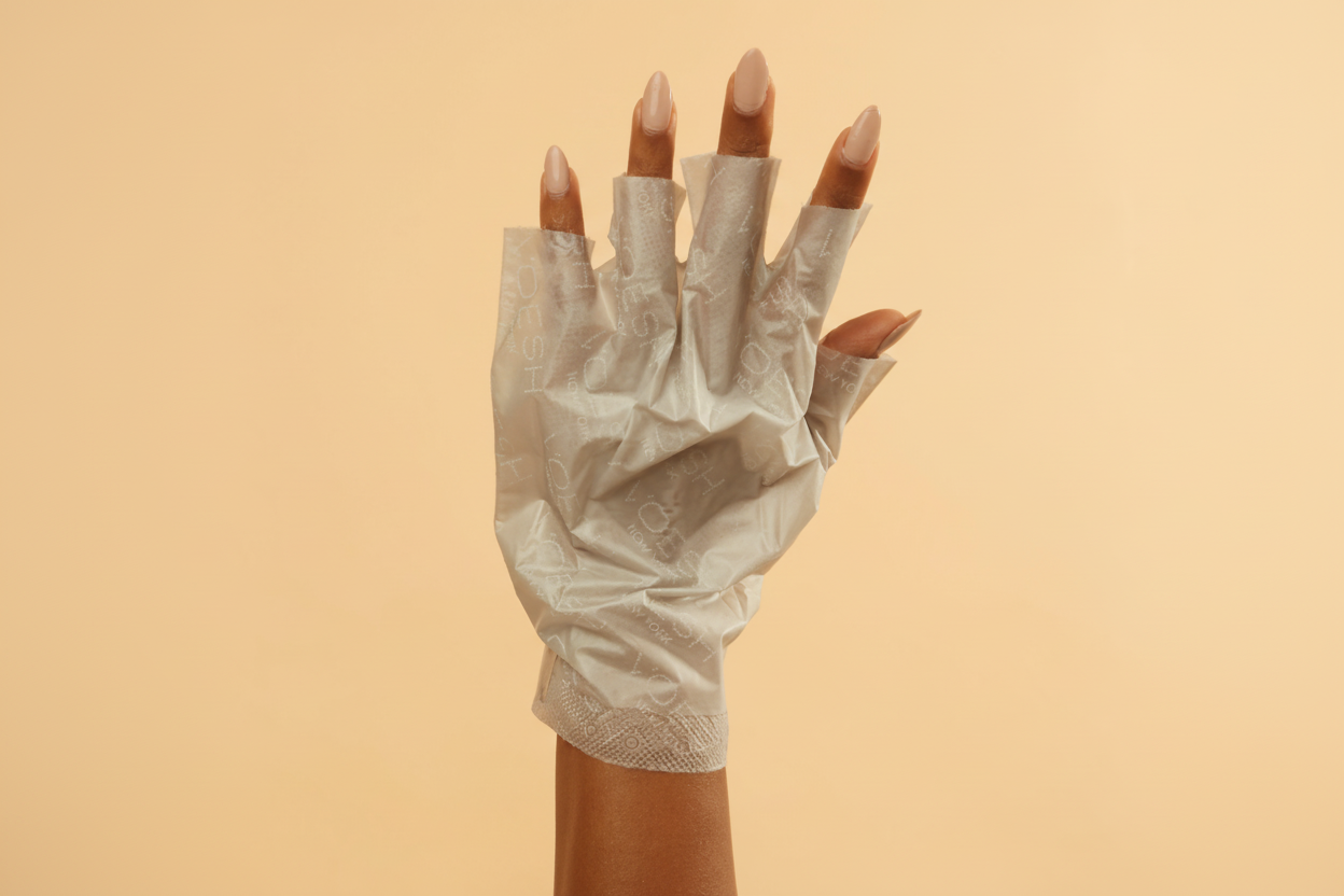 White lace glove on a hand against a beige background