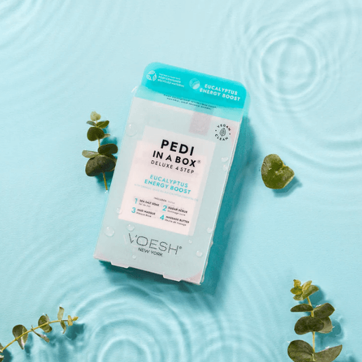 Pedi in a Box packaging on a light blue background with eucalyptus leaves.