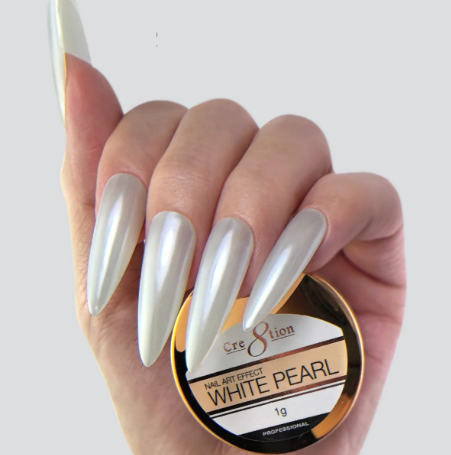 Hand with white pearl nail polish holding a container of the product.